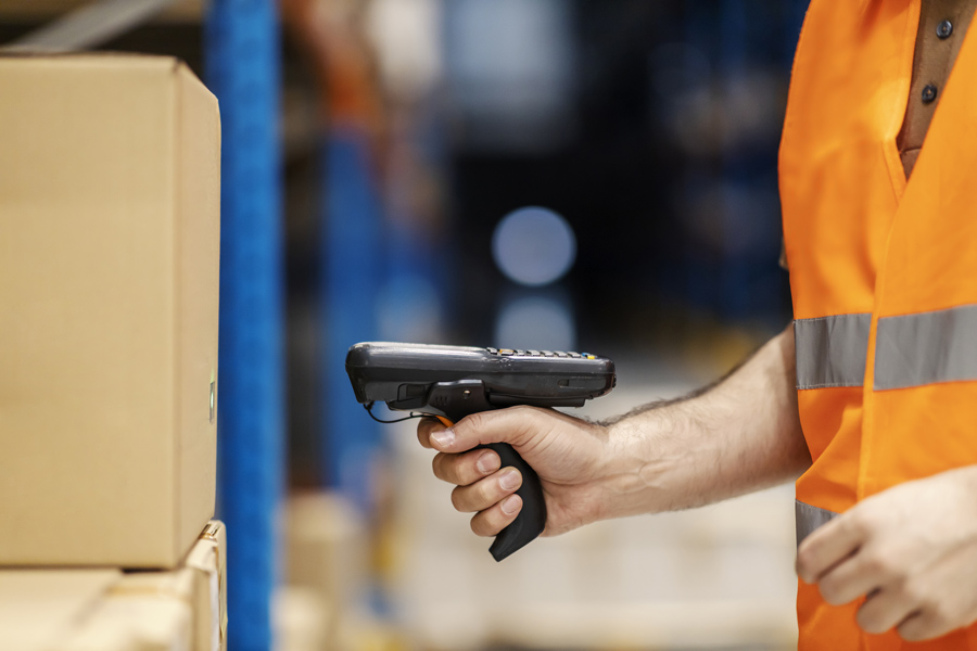 Operatore che utilizza uno scanner palmare industriale per identificare colli in magazzino
